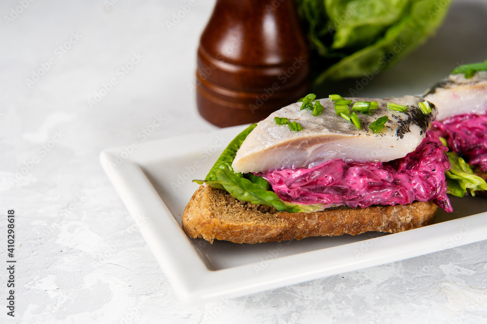 Close up of herring sandwich with beet and green salad on wooden board. Herring is a saurce of omega 3 fats healthy for brain and mental clarity. Brain food concept. Home cooking Close up of herring sandwich with beet and green salad on wooden board. Herring is a saurce of omega 3 fats healthy for brain and mental clarity. Brain food concept. Home cooking