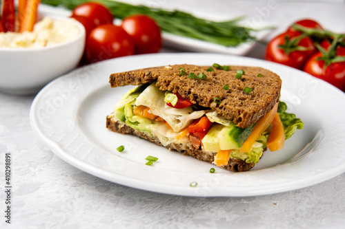 Close up of sandwich with hummus and vegetables on white plate. Healthy vegan diet food concept