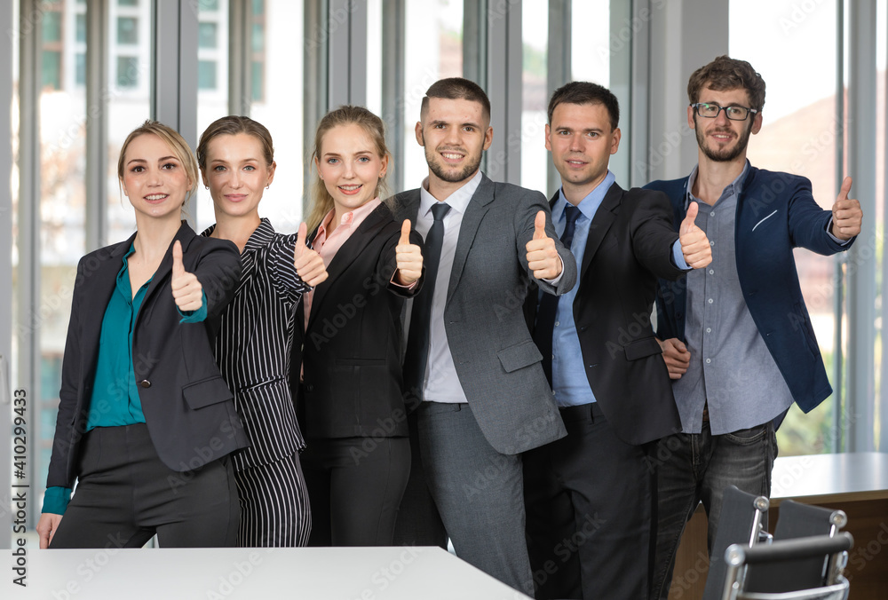Group of six business people team standing together rise finger for thumbs up symbol. Idea for teamwork in modern business Group of six business people team standing together rise finger for thumbs up symbol. Idea for teamwork in modern business