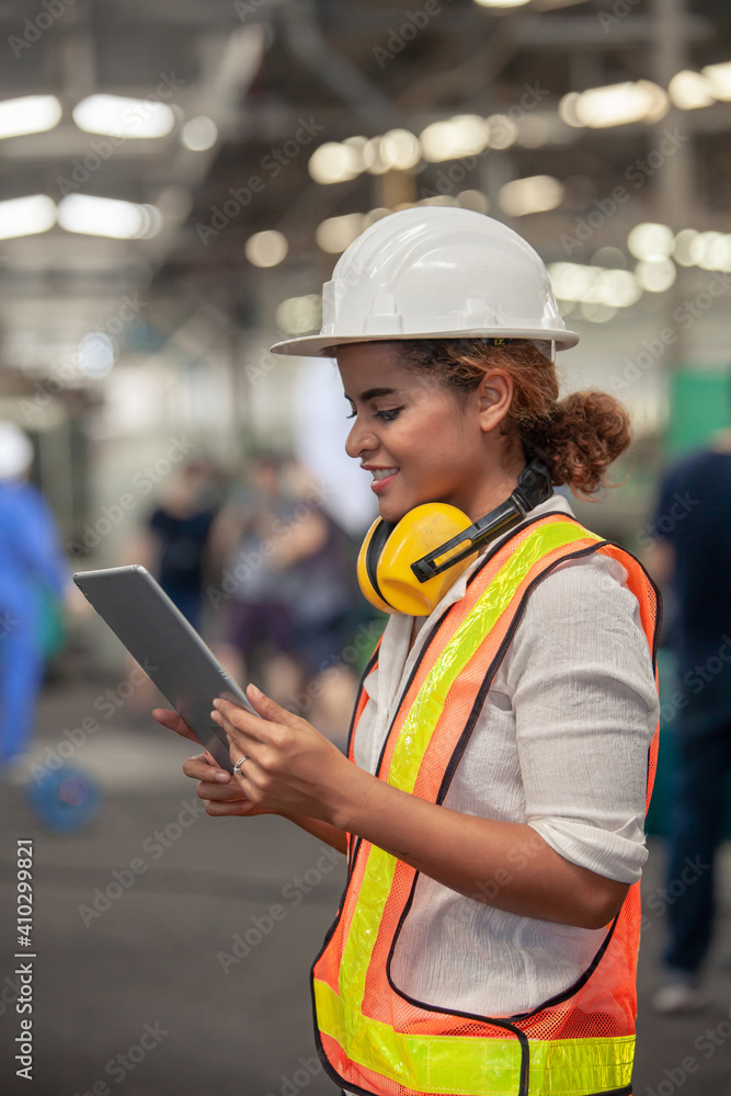 Engineer Female in using Tablet in Foundry worker in factory on the machine. portrait of an industrial Femal engineer with tablet in a factory. Engineer Female in using Tablet in Foundry worker in factory on the machine. portrait of an industrial Femal engineer with tablet in a factory.