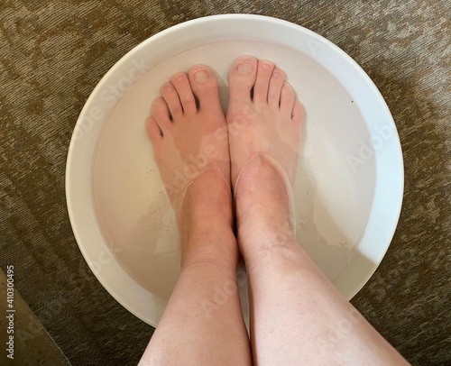 feet soaking in a bowl in a self care spa ritual  photo