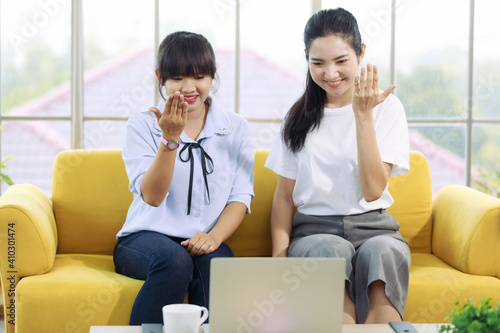 Young and beautiful Asain woman talk to someone on a notebook computer screen with hand sign, deaf language photo