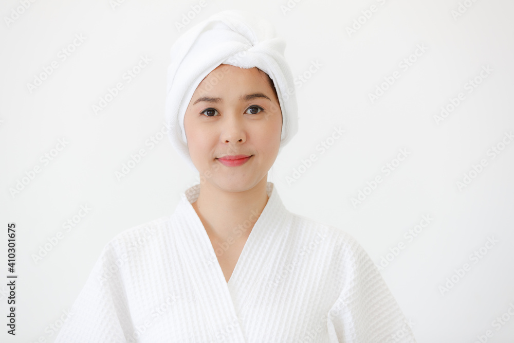 Portrait of middle age Asian woman with towel-covered around her head in the spa. She is smiling and looking at camera. Idea for female who care for health and skin Portrait of middle age Asian woman with towel-covered around her head in the spa. She is smiling and looking at camera. Idea for female who care for health and skin