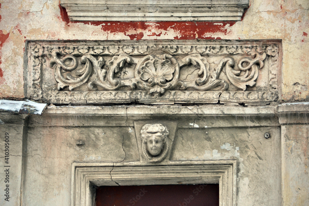 Elements of the architectural decor of the building. A fragment of the wall of an old stone house with peeling plaster. Elements of the architectural decor of the building. A fragment of the wall of an old stone house with peeling plaster.
