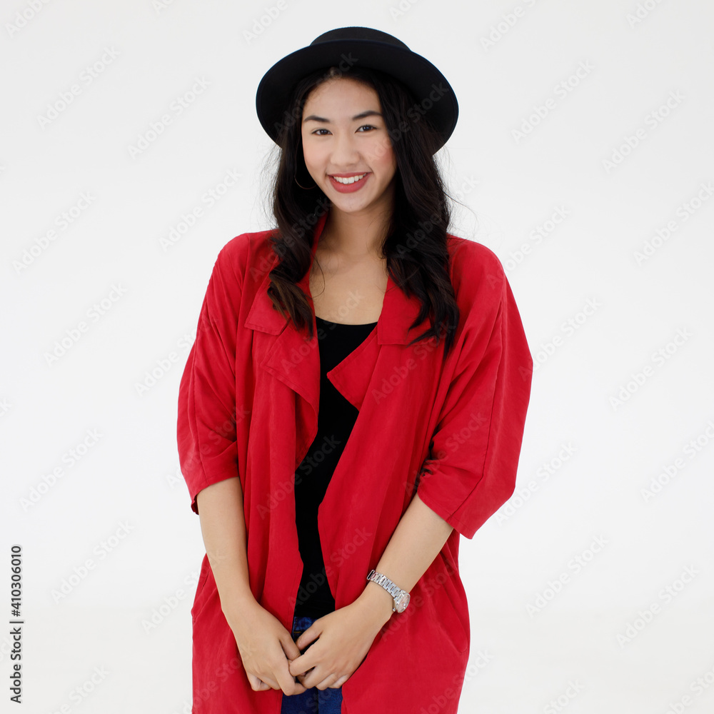 Portrait of beautiful Asian woman with a black hat on her head wearing a stylish red shirt over a black T-shirt and blue jean pants looking at a camera. Joyful and positive person concept Portrait of beautiful Asian woman with a black hat on her head wearing a stylish red shirt over a black T-shirt and blue jean pants looking at a camera. Joyful and positive person concept