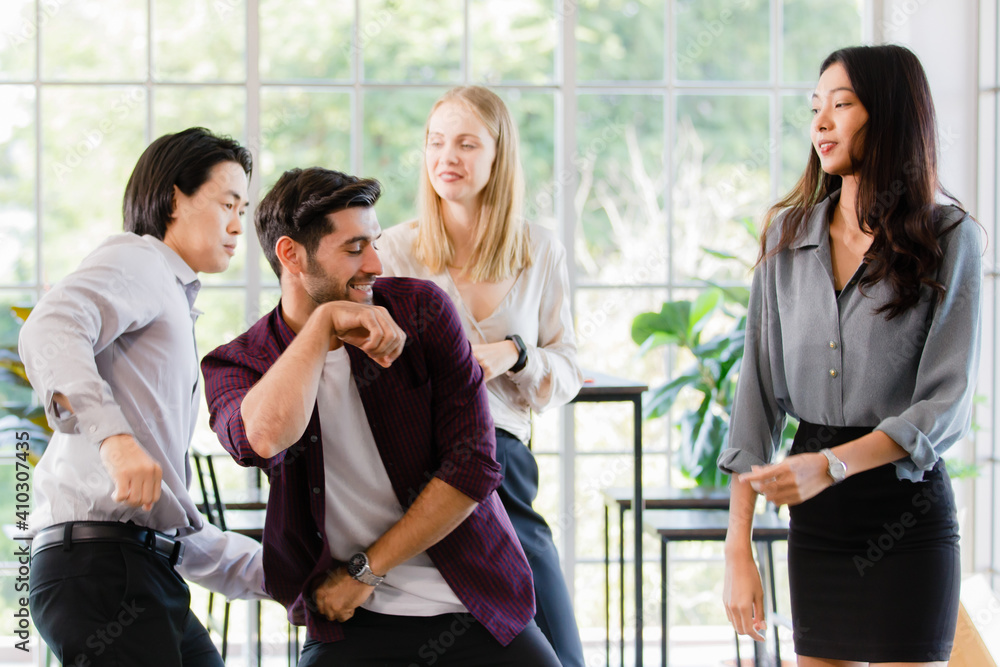 Obraz premium Group of diverse businesspeople, caucasian and Asian, dancing together with happiness and intimate in office. Idea for teamwork and good business colleagues