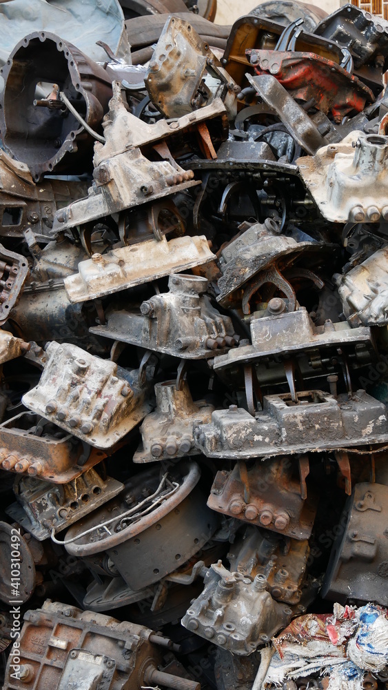 Pile of old machine parts in second hand machinery shop, background of damage and rusty old car machine