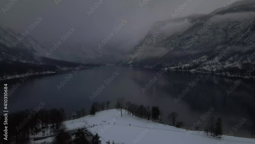 Aerial View of Dark Winter Day Above Mountain Lake, Snow Capped Misty Lakeside, Drone Shot Aerial View of Dark Winter Day Above Mountain Lake, Snow Capped Misty Lakeside, Drone Shot