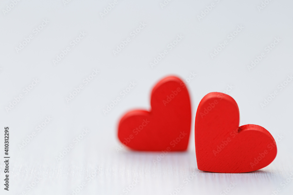 Two small red hearts made of wooden on bright white lights bokeh background. Valentine day background Two small red hearts made of wooden on bright white lights bokeh background. Valentine day background