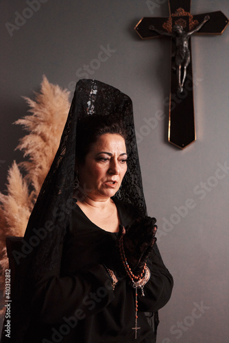 Middle-aged woman praying with a rosary