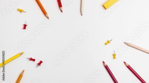 Red and yellow pen, sticky note, notepad, marker, eraser, push pins, paper clip pencils on white background. Stop motion animation flat lay top view Education back to school online study copy space