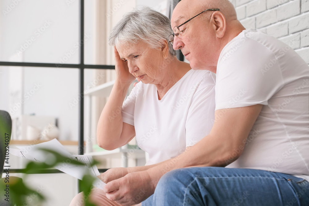 Obraz premium Stressed senior couple in debt at home