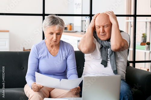 Stressed senior couple in d...