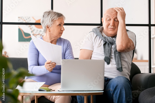Stressed senior couple in d...