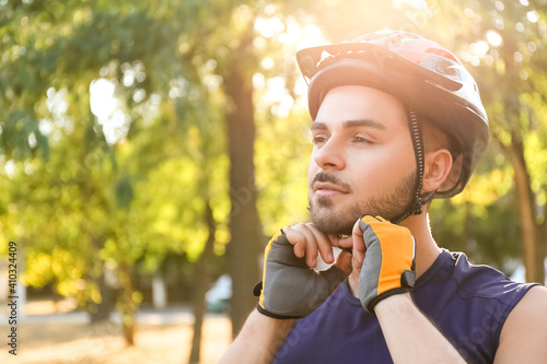 Male cyclist putting on hel...