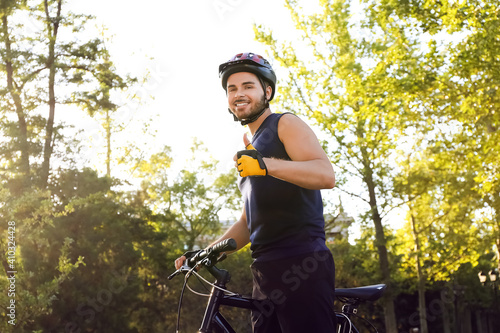 Male cyclist with bicycle showing thumb-up outdoors © Pixel-Shot