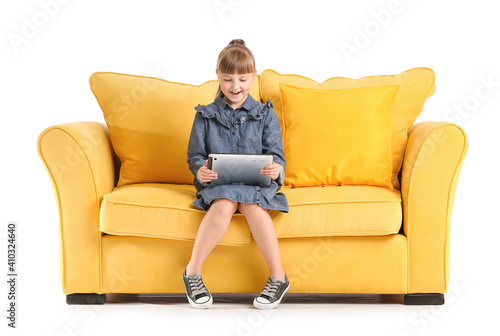 Little girl with tablet computer on sofa against white background