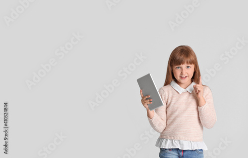 Little girl with tablet com...