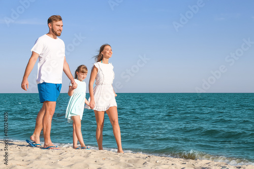 Happy family walking on sea...