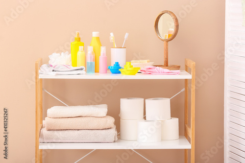 Shelf unit with bath accessories near color wall