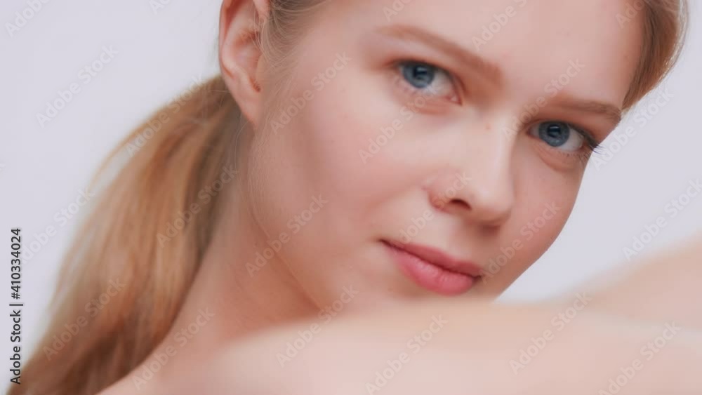 Extreme close-up beauty portrait of young blonde woman touches her skin running finger along a forearm and looks at the camera through all this mess | Skin care product results concept Extreme close-up beauty portrait of young blonde woman touches her skin running finger along a forearm and looks at the camera through all this mess | Skin care product results concept