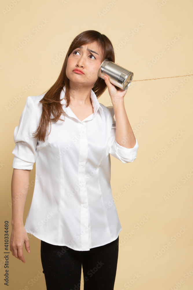 Young Asian woman with tin can phone. Young Asian woman with tin can phone.