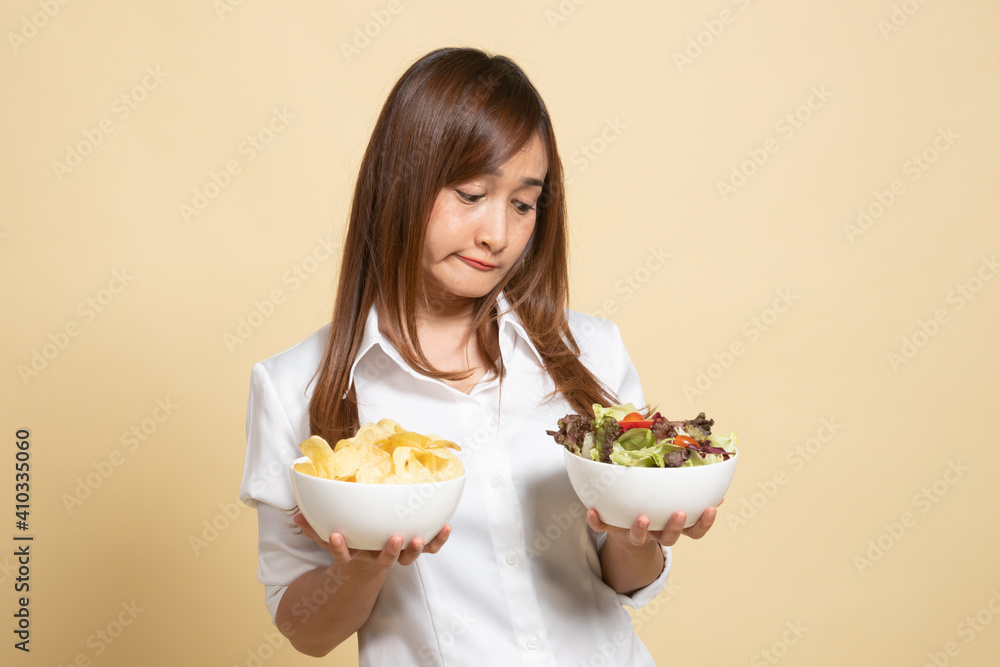 Young Asian woman with potato chips and salad. Young Asian woman with potato chips and salad.