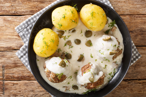 German Meatballs in Gravy with capers Konigsberger Klopse close-up in a plate on the table. Horizontal top view above photo