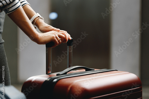 Unrecognizable businesswoman standing with travel bag close up photo