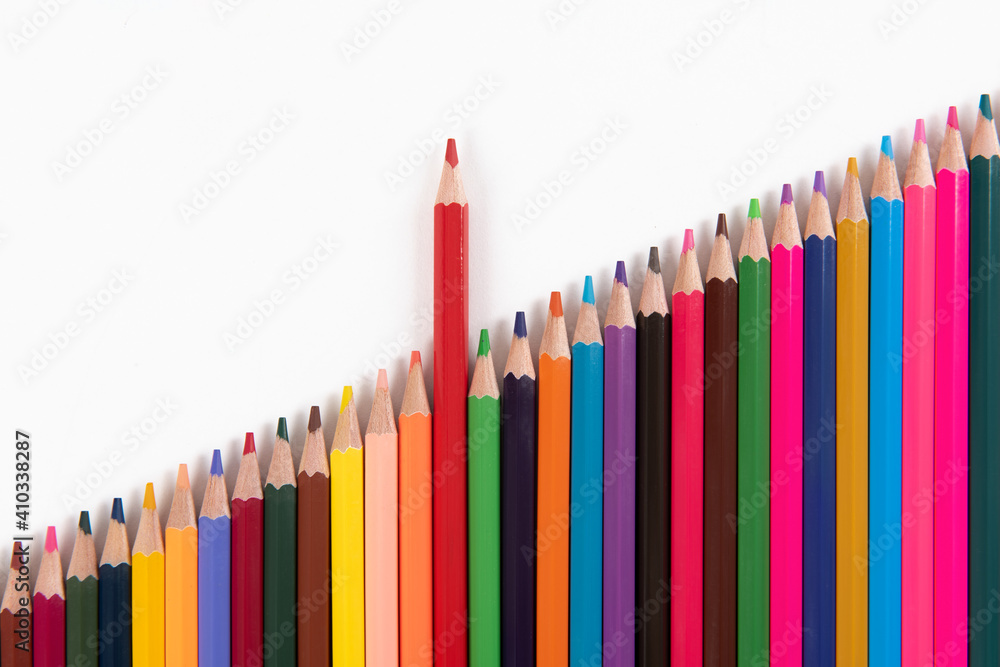 Fototapeta premium One pencil standing out from the group of other pencil on white background