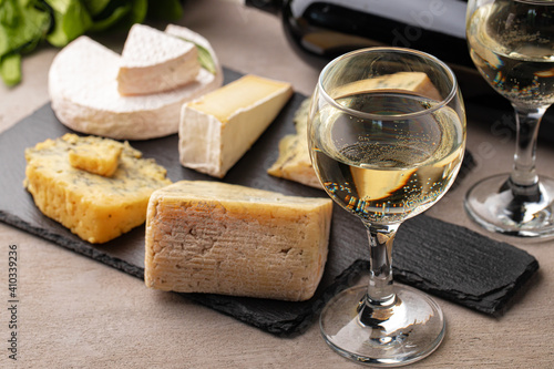 Different types of cheese and wine on gray table