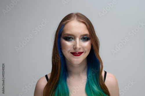 Photo portrait of a model with excellent makeup. Caucasian girl with long dyed hair
