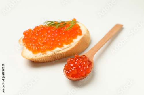 Sandwich and spoon with red caviar on white background