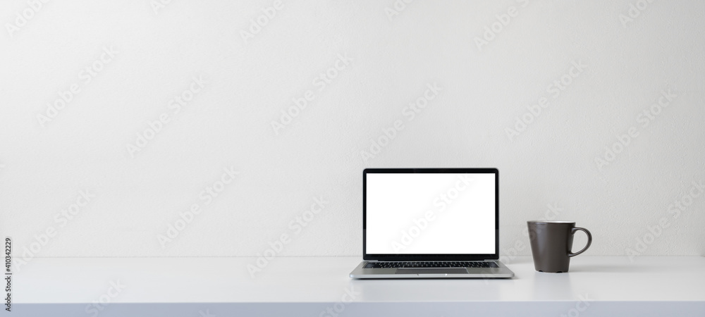 Modern contemporary workspace with blank screen laptop computer and coffee cup on office desk table on white background for copy space. Home office workplace concept. Modern contemporary workspace with blank screen laptop computer and coffee cup on office desk table on white background for copy space. Home office workplace concept.