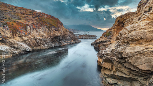 Beautiful seascape, ocean views, rocky coast, sunlight on the horizon. Composition of nature. Sunset scenery background. Cloudy sky. Water Reflection. California Seashore.