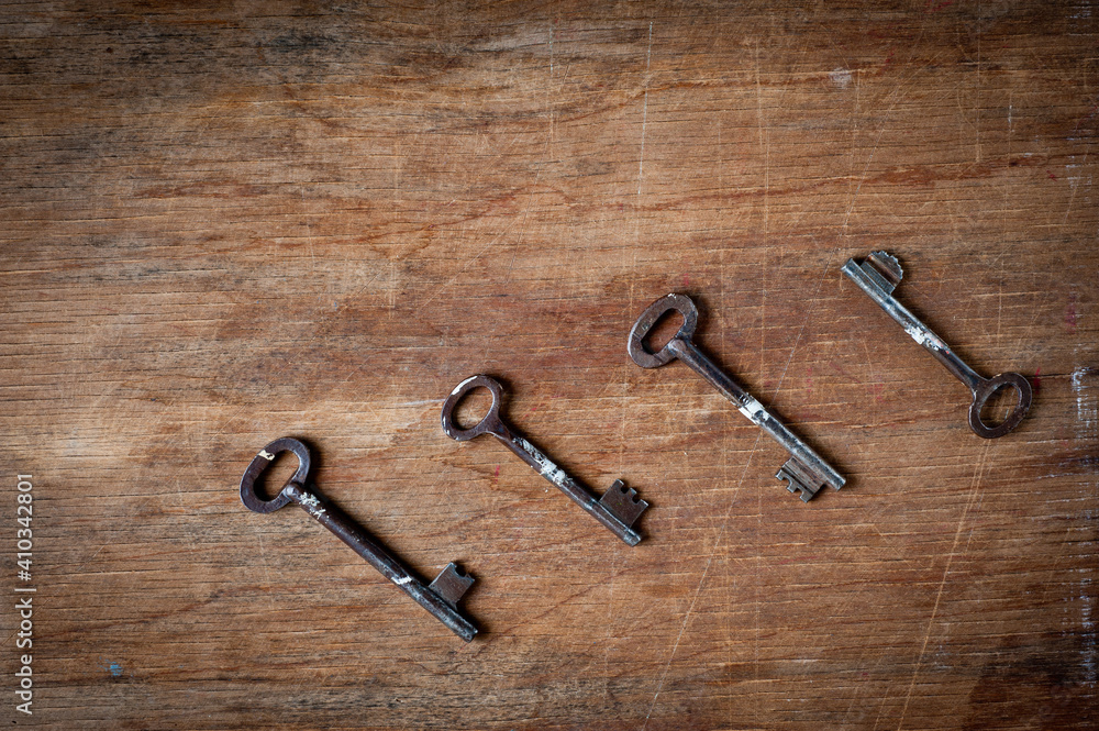 Old iron door keys lying on an old wooden surface. Old iron door keys lying on an old wooden surface.