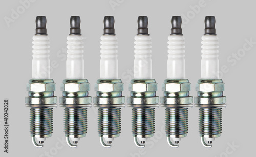 Six spark plugs isolated on gray background.