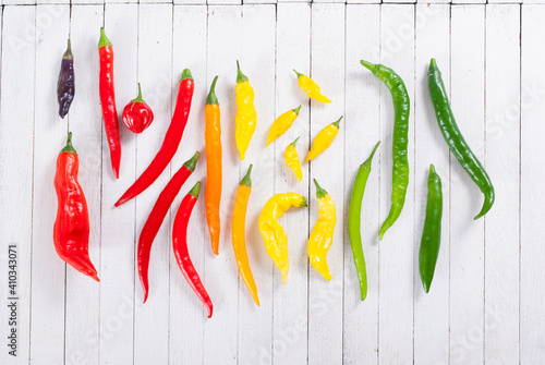 chili peppers selection on white wood table background photo