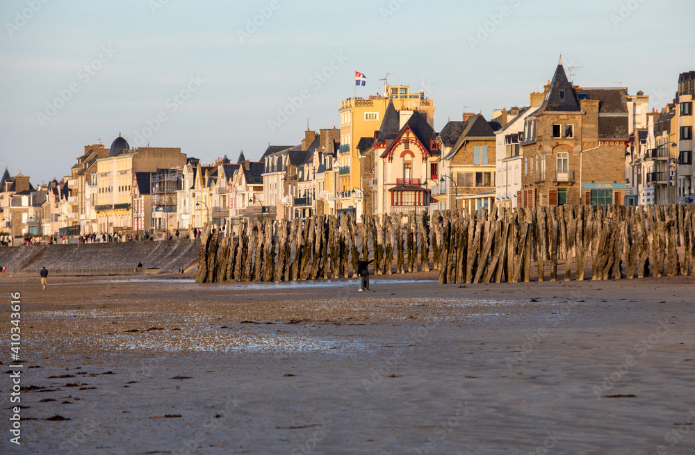 Fototapeta premium Beach in the evening sun and buildings along the seafront promenade in Saint Malo. Brittany, France