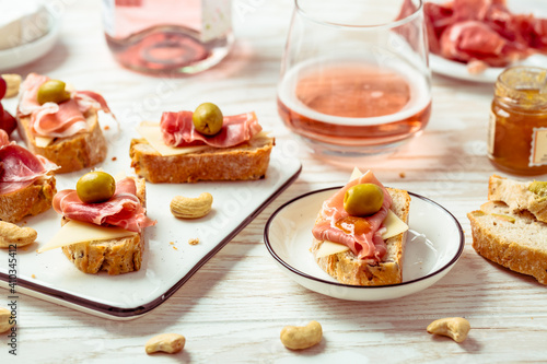 Appetizers and open sandwiches with Italian antipasti, camembert, Parma ham and rose wine