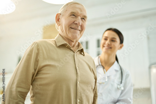 Cheerful elderly man being examined by a medical worker