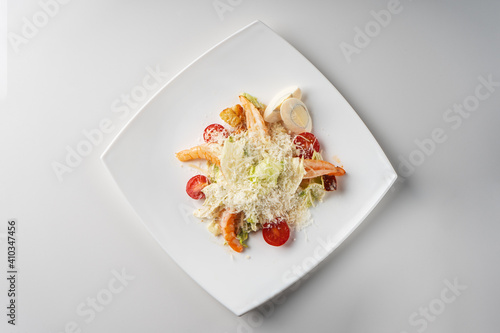 Caesar with prawns on a white square plate top view