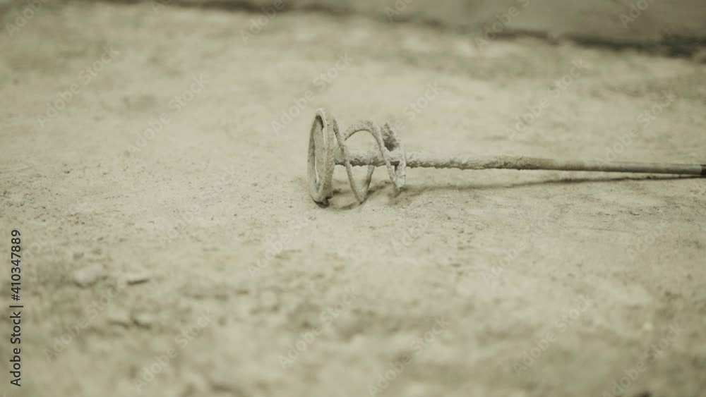 Construction mixer nozzle for mixing mortar for the drill lies on the floor Construction mixer nozzle for mixing mortar for the drill lies on the floor