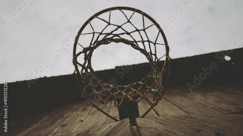 Basketball hoop with a net on the wall of a wooden barn outside the city. Against the background of the sky in the clouds in autumn.