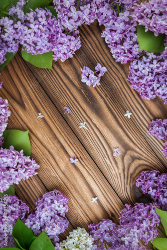 Lilac flowers on a wooden background as a frame  idea  concept backdrop texture.