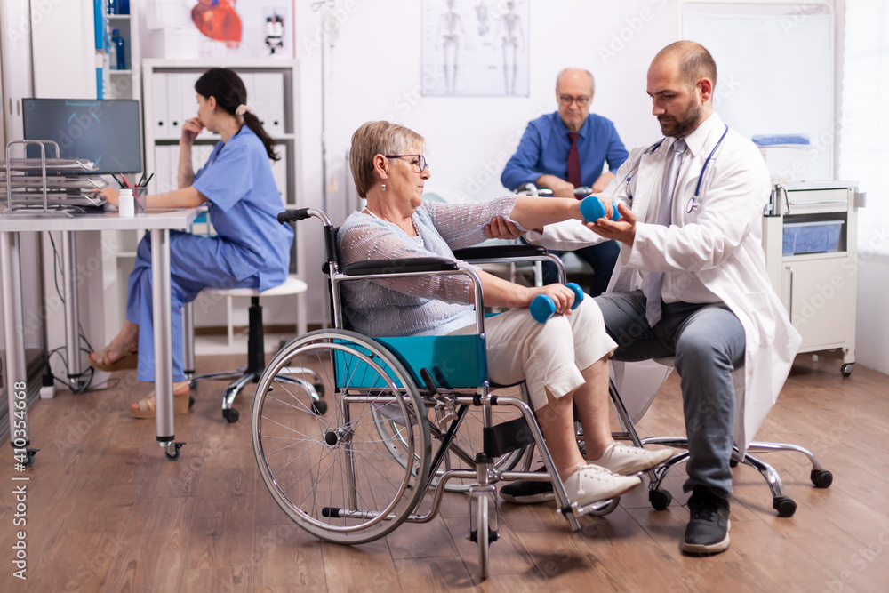 Handicapped patient getting help from physical therapist. Elderly invalid patients in hospital following rehabilitation treatment with help from medical personal. Handicapped patient getting help from physical therapist. Elderly invalid patients in hospital following rehabilitation treatment with help from medical personal.