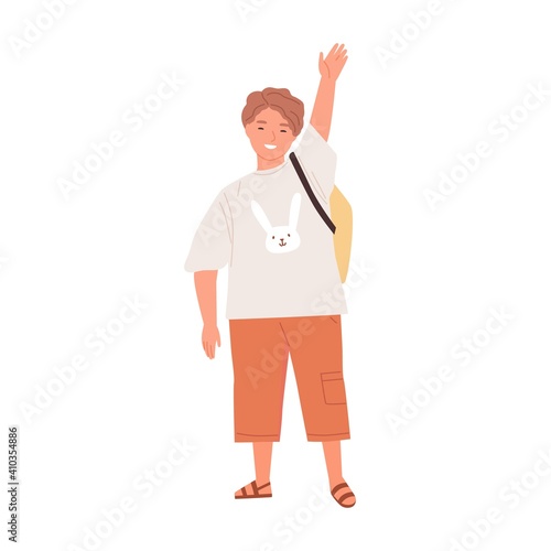 Positive smiling schoolboy waving with hand raised up. Happy friendly boy sta...