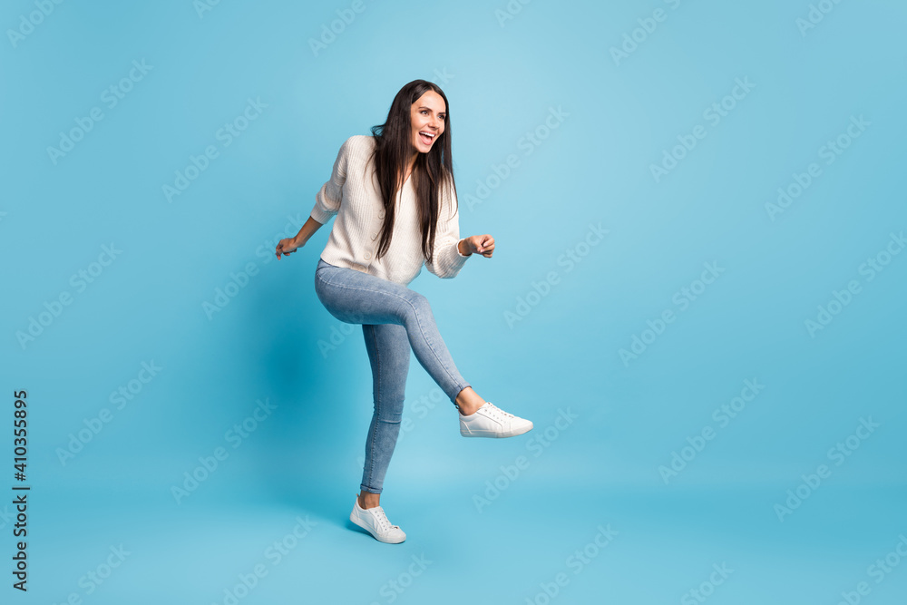 Full size profile photo of carefree lady look empty space enjoy dancing partying isolated on blue color background Full size profile photo of carefree lady look empty space enjoy dancing partying isolated on blue color background