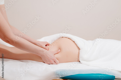 Anticellulite massage. The masseuse massages the woman s thigh and buttock. Movement of the masseur s hands on the thigh.