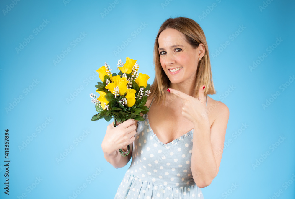 Portrait of a beautiful young woman holding big bouquet of flowers isolated over blue background. Portrait of a beautiful young woman holding big bouquet of flowers isolated over blue background.